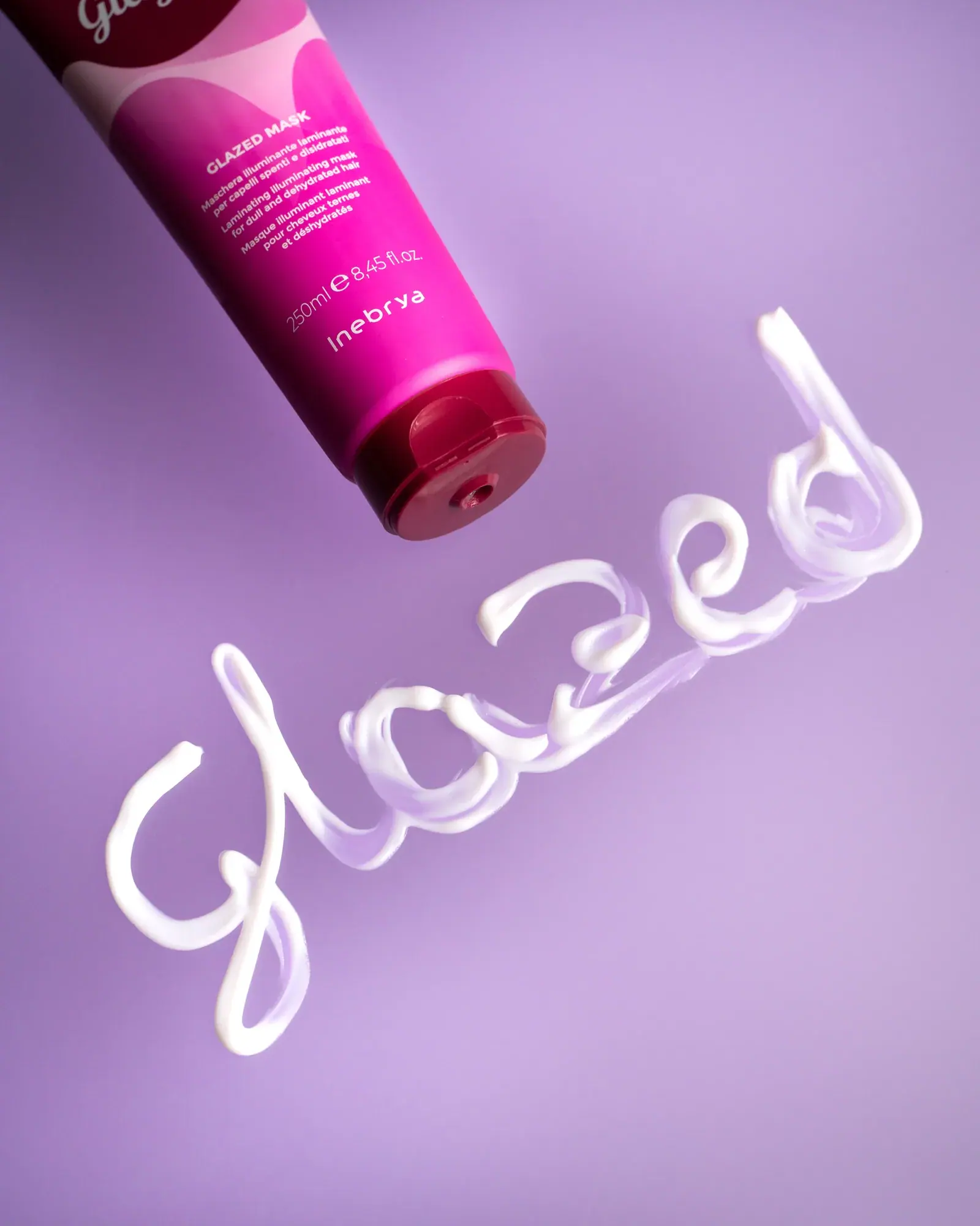 Bisnaga Shecare Glazed em diagonal, com o nome da linha desenhado em creme